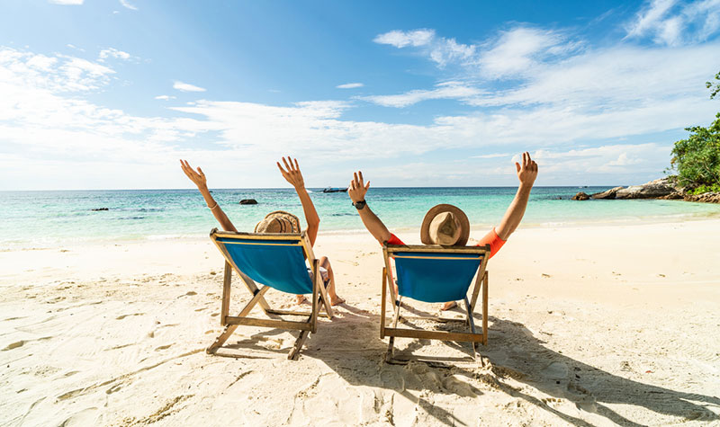 Entusiastiskt par sitter i solstolar på stranden luftgitarrist